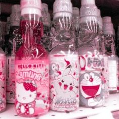 many hello kitty bottles are lined up on the shelf