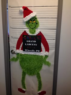 the grinch is holding a sign on his door