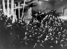 an old black and white photo of people in front of a crucifix