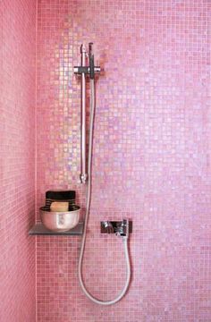 a pink tiled bathroom with a shower head