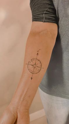 a person with a compass tattoo on their arm