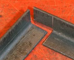 two metal trays sitting on top of a red table next to each other,