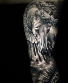 a man's arm with a horse and wings tattoo on the left side of his arm