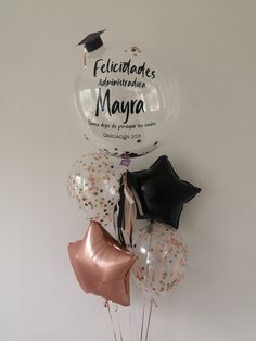 balloons and confetti in the shape of stars are arranged on a white wall