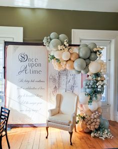 a chair sitting in front of a large balloon arch