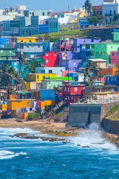 the colorful houses are all over the water and on the hill above them is an ocean view