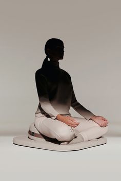 a woman sitting on top of a white object