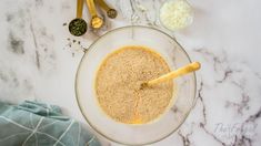 a bowl filled with oatmeal sitting on top of a counter next to measuring spoons