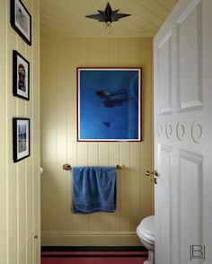 a bathroom with pictures on the wall and a blue towel hanging in front of it