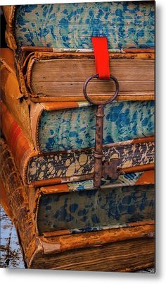 several books stacked on top of each other with an iron hook attached to the book ends