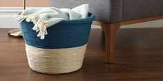 a blue and white basket sitting on top of a wooden floor next to a chair