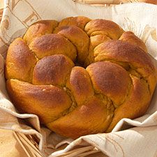 a loaf of bread sitting on top of a table next to a basket filled with bread