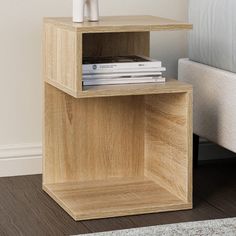 a small wooden shelf next to a bed