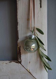 an ornament hanging from the side of a wall next to a green plant