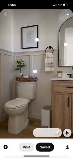 a white toilet sitting next to a bathroom sink under a mirror on top of a wooden cabinet