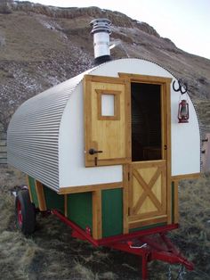 a small white and green house on wheels