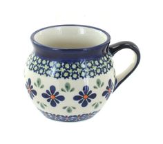 a blue and white pitcher with flowers on it