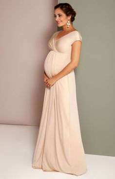 a pregnant woman in a dress posing for the camera