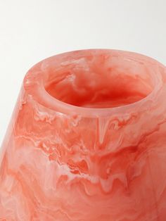 a pink vase sitting on top of a white table