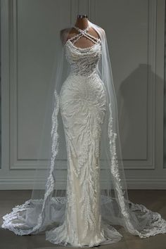 a white wedding dress on display with a veil over it's head and shoulders