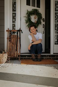 a woman sitting on the front steps of a house