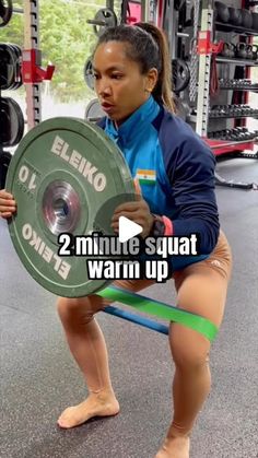 a woman squatting down with a barbell in her hand and the words, 2 minute squat warm up