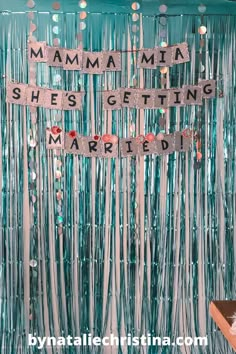 a party backdrop with the words mamma she's getting married and streamers