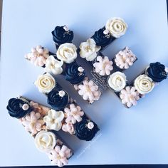 several cupcakes with white and black frosting on them are arranged in the shape of flowers