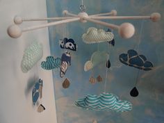 a mobile made to look like clouds and fish hanging from it's sides in a child's room