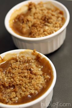 two white bowls filled with food sitting on top of a black table next to each other