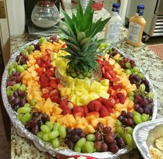 a platter filled with lots of different types of fruit on top of a counter