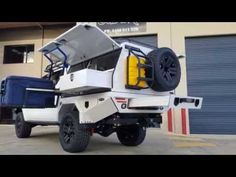 an off - road vehicle parked in front of a garage door with the doors open