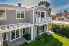 an aerial view of a two story house with white trim and gray siding on the side