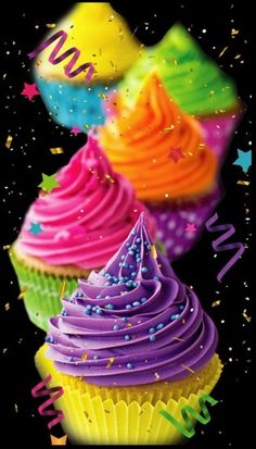 colorful cupcakes with confetti and streamers in the air on a black background