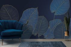 a blue chair sitting on top of a wooden floor next to a wall covered in leaves