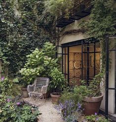 an outdoor patio area with potted plants and a metal chair in the foreground