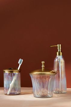 a bathroom set consisting of soap dispenser, toothbrush holder and glass container