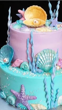 there is a multi layer cake decorated with shells and seashells