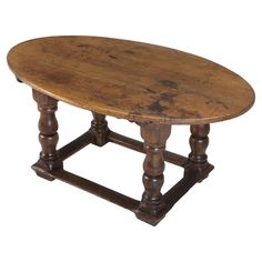 an old wooden table with turned legs and a round top, on a white background