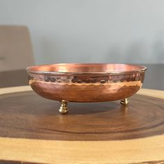 a metal bowl sitting on top of a wooden table