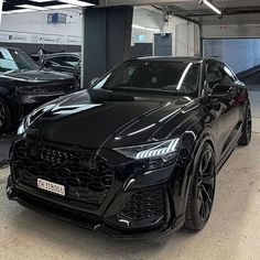 a black car parked in a garage next to other cars