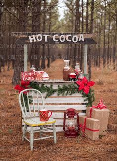 a white bench sitting in the middle of a forest next to a sign that says hot cocoa