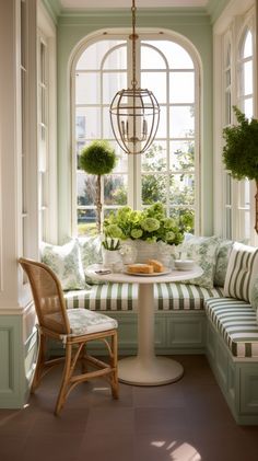 a breakfast nook in the corner of a room with green and white striped cushions