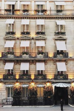 an old building with many windows and awnings on the outside, lit up at night