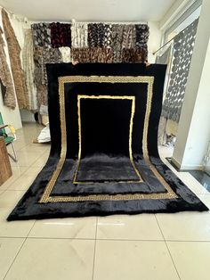 a black and gold photo studio set up in the middle of a room filled with rugs