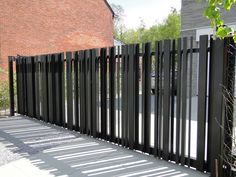 a black metal fence is next to a brick building