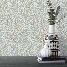 a vase filled with flowers sitting on top of a table next to a wall paper