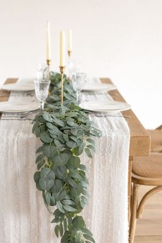 the table is decorated with greenery and candles