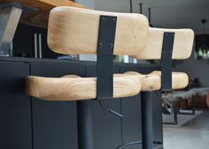 two wooden barstools sitting next to each other in front of a kitchen counter