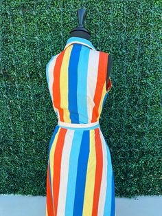 Get ready to turn heads this summer with our Summer Stripes Maxi Dress! The stunning vertical stripes in blue, yellow, and orange will elongate your figure while adding a playful touch. Plus, with pockets, a button-up design, and a flattering belted waist, you'll look and feel effortlessly chic. Maximize your summer style with this must-have dress. Striped Collared Vacation Dress, Striped Collared Dresses For Vacation, Striped Collared Beach Dress, Collared Striped Beach Dress, Spring Striped Collared Dress, Cotton Dress With Vertical Stripes For Day Out, Retro Striped Knee-length Dress, Striped Lined Sundress, Striped Sundress With Lining